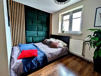 a bedroom with a bed with a black headboard at Dom w Kryspinowie in Kryspinów