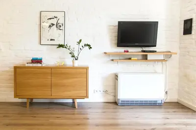 a living room with a television and a dresser at Garden Studio in Kraków