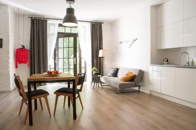 a kitchen and living room with a table and chairs at Garden Studio in Kraków