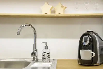 a kitchen counter with a coffee maker and a sink at Garden Studio in Kraków