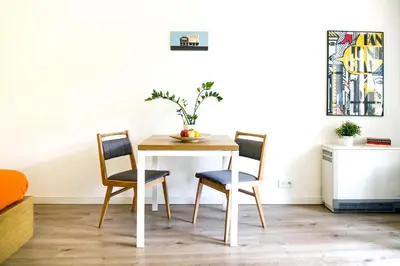 a dining room table with two chairs and an orange bowl on it at Garden Studio in Kraków