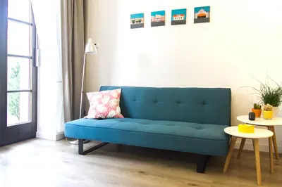 a blue couch in a living room with a table at Garden Studio in Kraków