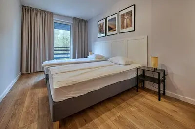 a bedroom with a large bed and a table at Przytulne M w Pcimiu in Pcim