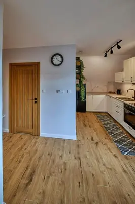 an empty kitchen with a clock on the wall at Przytulne M w Pcimiu in Pcim