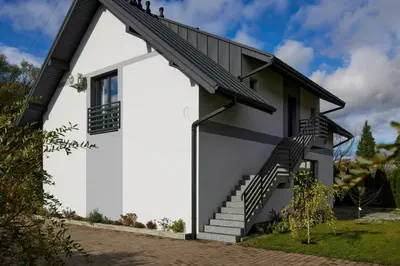 a white house with stairs on the side at Przytulne M w Pcimiu in Pcim