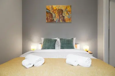 a bedroom with a bed with three towels on it at Househost Apartment Paulinska 20 in Kraków