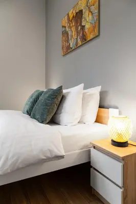a bedroom with a bed with white sheets and pillows at Househost Apartment Paulinska 20 in Kraków