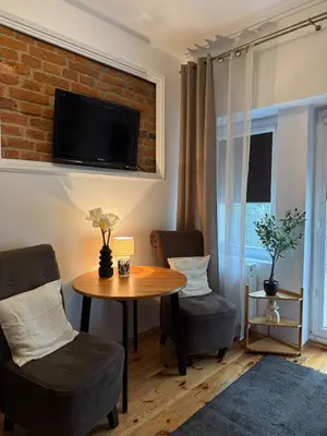 a living room with a table and two chairs at Cozy Central Kraków Studio - Walk to Wawel - Fast Wi-Fi & Smart TV in Kraków
