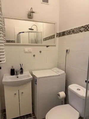 a bathroom with a toilet and a sink and a mirror at Cozy Central Kraków Studio - Walk to Wawel - Fast Wi-Fi & Smart TV in Kraków