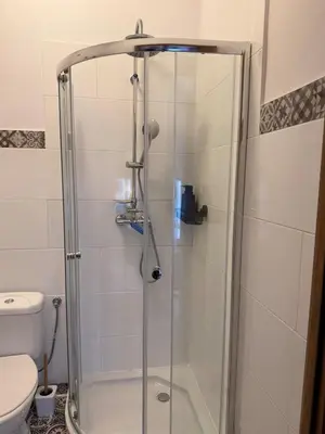 a shower with a glass door in a bathroom at Cozy Central Kraków Studio - Walk to Wawel - Fast Wi-Fi & Smart TV in Kraków