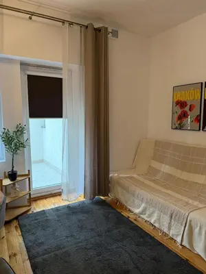 a bedroom with a bed and a large window at Cozy Central Kraków Studio - Walk to Wawel - Fast Wi-Fi & Smart TV in Kraków