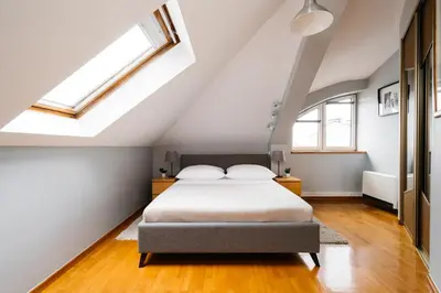 a attic bedroom with a bed and skylights at Native Apartments Warszauera 3 in Kraków