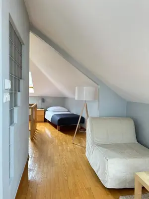 a bedroom with a bed and a couch in a attic at Native Apartments Warszauera 3 in Kraków