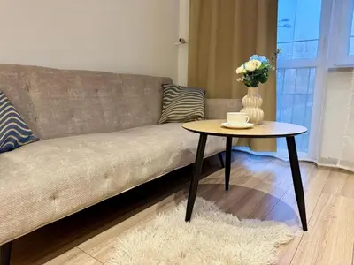 a living room with a couch and a table with a vase of flowers at Apartament Bałandy 18 in Oświęcim