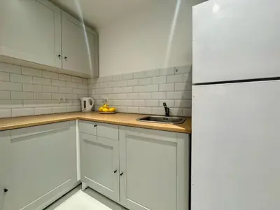a kitchen with white cabinets and a white refrigerator at Apartament Bałandy 18 in Oświęcim
