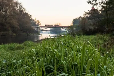 a bridge over a river with a field of grass at Apartament Bałandy 18 in Oświęcim