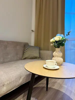 a coffee table with a vase of flowers and a coffee cup at Apartament Bałandy 18 in Oświęcim