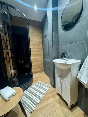 a bathroom with a shower and a sink and a mirror at Apartament Bałandy 18 in Oświęcim