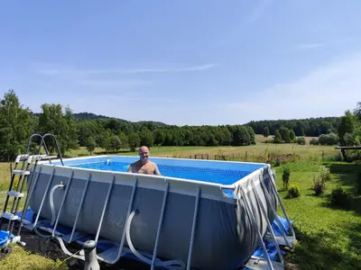 a man is standing in a swimming pool at Jura - Chata pod Grodziskiem Pańskim in Domaniewice