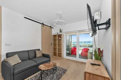 a living room with a couch and a tv at Imperial Capital Apartments by BookingHost in Kraków
