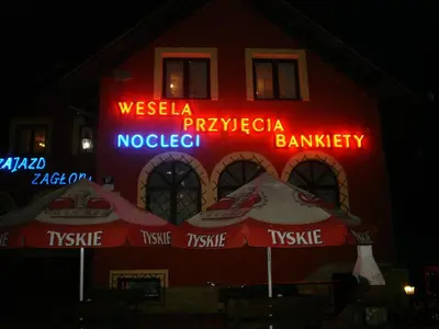 a building with neon signs on the side of it at Zajazd Zagłoba in Widoma