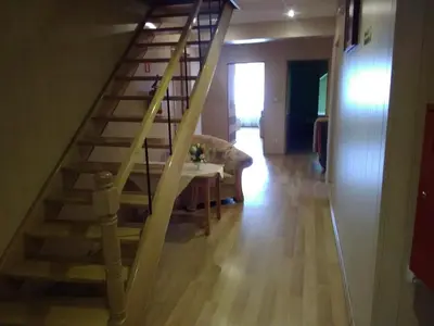 a wooden staircase in a living room with a table at Zajazd Zagłoba in Widoma