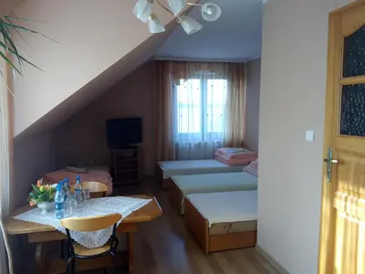 a living room with a table and a room with a bed at Zajazd Zagłoba in Widoma