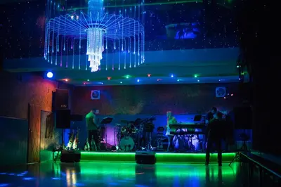 a stage with a chandelier and a group of people at Zajazd Zagłoba in Widoma