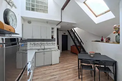 a kitchen with white cabinets and a table with chairs at Urbannest-Augustiańska 4 in Kraków