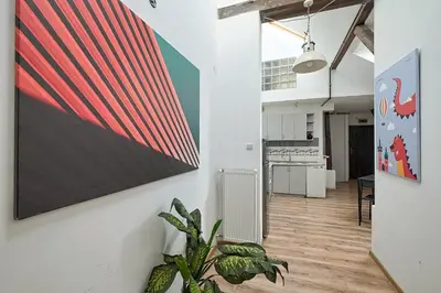a kitchen with a large painting on the wall at Urbannest-Augustiańska 4 in Kraków