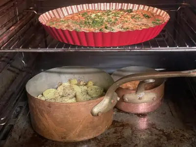 two pots of food are sitting in an oven at Villatopol Art Hostel in Rząska