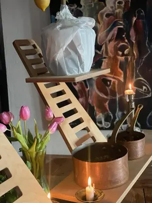 a wooden shelf with a pot and candles on a table at Villatopol Art Hostel in Rząska
