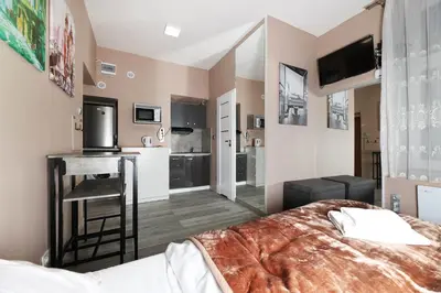 a bedroom with a bed and a kitchen with a counter at Zyblikiewicza 11 by Homeprime in Kraków