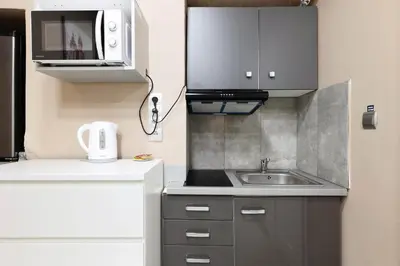 a small kitchen with a sink and a microwave at Zyblikiewicza 11 by Homeprime in Kraków