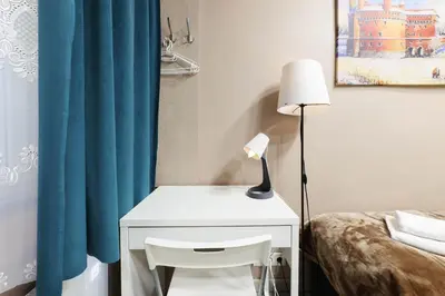 a white desk with a lamp next to a bed at Zyblikiewicza 11 by Homeprime in Kraków