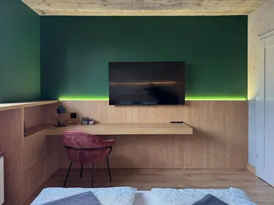 a living room with a tv and a red chair at Green Point - Design Apartaments in Kraków