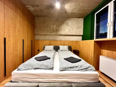 a bedroom with a bed with two pillows on it at Green Point - Design Apartaments in Kraków
