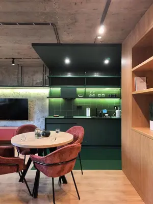 a kitchen with green cabinets and a table and chairs at Green Point - Design Apartaments in Kraków