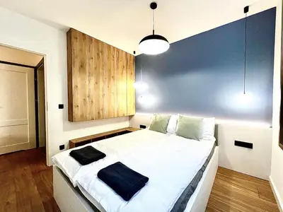 a bedroom with a large white bed with a blue wall at Old Town Krakow Loft - Design Apartaments in Kraków