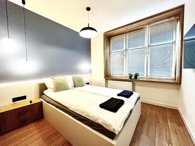 a small bedroom with a bed with a window at Old Town Krakow Loft - Design Apartaments in Kraków