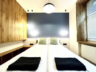 a bedroom with a large white bed with two black pillows at Old Town Krakow Loft - Design Apartaments in Kraków