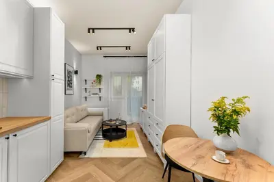a kitchen and living room with a table and a couch at Apartament Lea Garden in Kraków