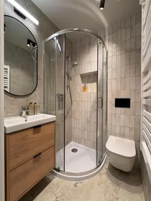 a bathroom with a shower and a sink and a toilet at Apartament Lea Garden in Kraków