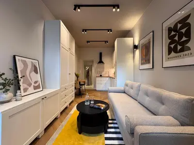 a living room with a couch and a table at Apartament Lea Garden in Kraków
