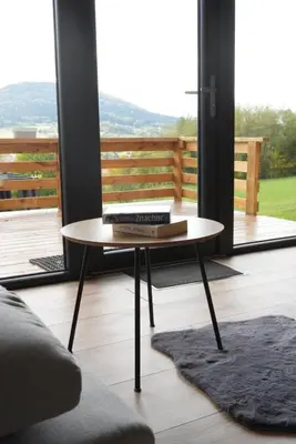 a coffee table with books on it in a living room at Zachód Beskidu domek z Jacuzzi na wyłączność in Nowe Rybie