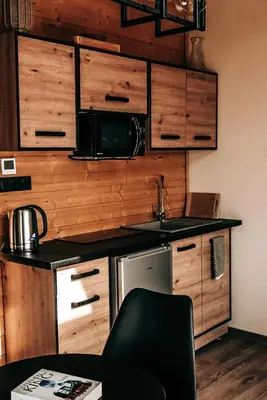 a kitchen with wooden cabinets and a black counter top at Zachód Beskidu domek z Jacuzzi na wyłączność in Nowe Rybie