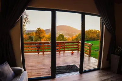 a sliding glass door with a view of a deck at Zachód Beskidu domek z Jacuzzi na wyłączność in Nowe Rybie