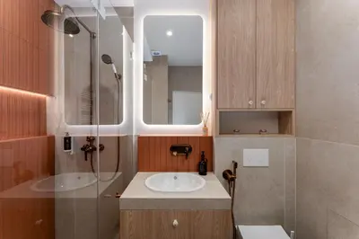 a bathroom with a sink and a glass shower at San Benedetto Stylish Apartments in Kraków