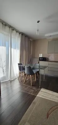 a living room with chairs and a table and a kitchen at Silent Apt Pychowicka in Kraków