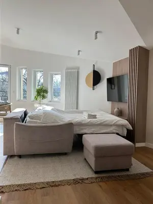 a bedroom with a bed and a couch and a tv at Cracow Center Jacuzzi & Sauna Penthouse Retreat in Kraków